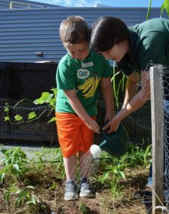 Charlie Vaughan works with Horticulturist Chandra Metheny during Farmyard Bash camp in 2016