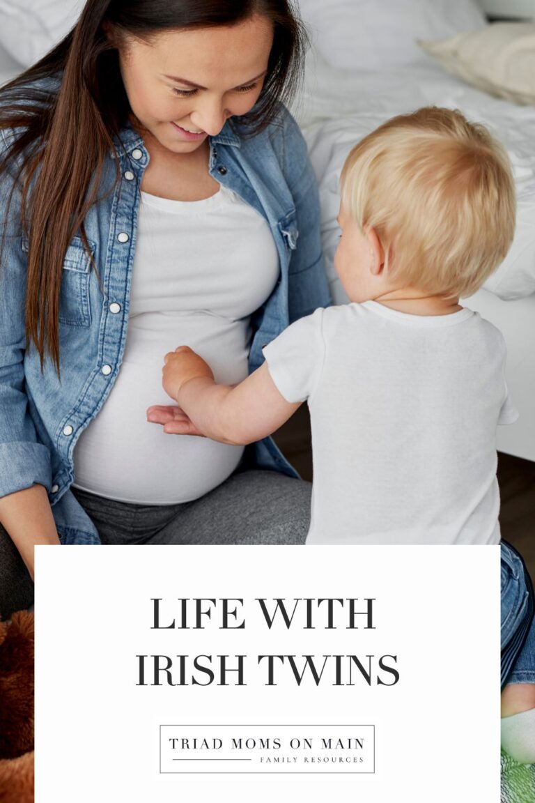 Mom pregnant with irish twins with her toddler pointing to her belly