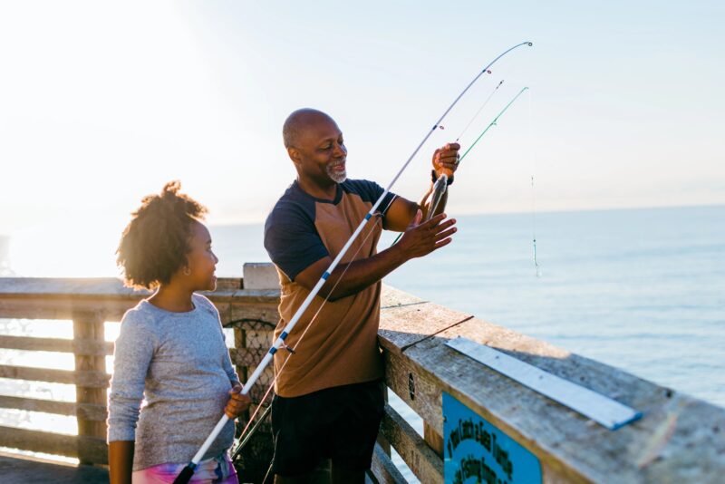 Grandfather fishing with granddaughter at Jennette's Pier in Nags Head, NC