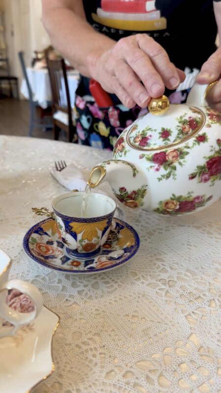 Teapot pouring tea in a tea cup at The Book & Bee in Hendersonville, NC