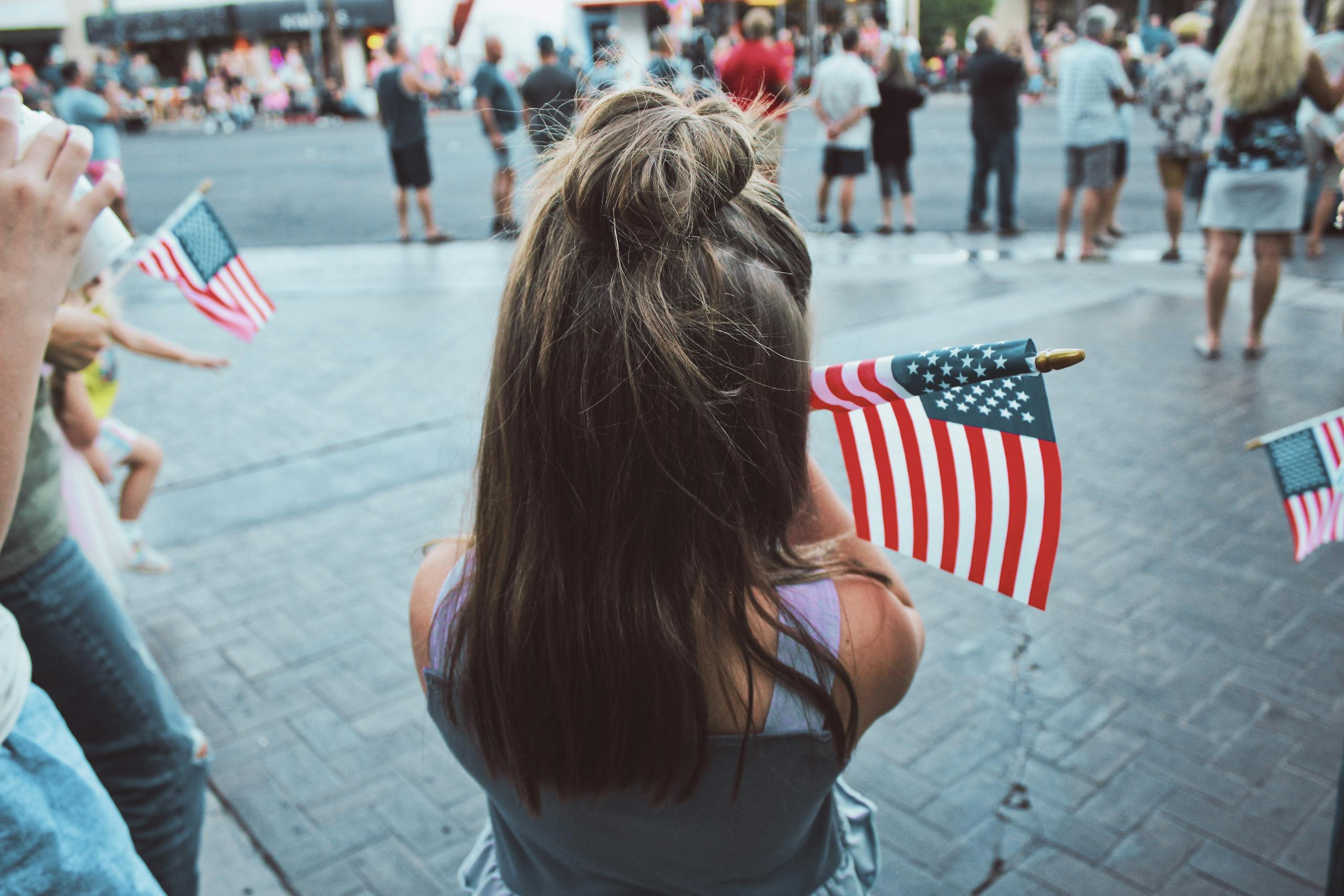 Children waving flags at a Veterans Day parade.