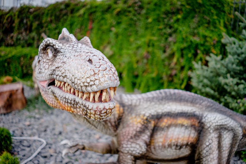 Close-up of a detailed dinosaur model outdoors, showcasing intricate features.